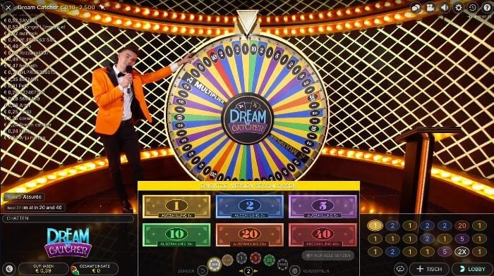 A man in an orange-colored jacket stands next to a colorful wheel of fortune